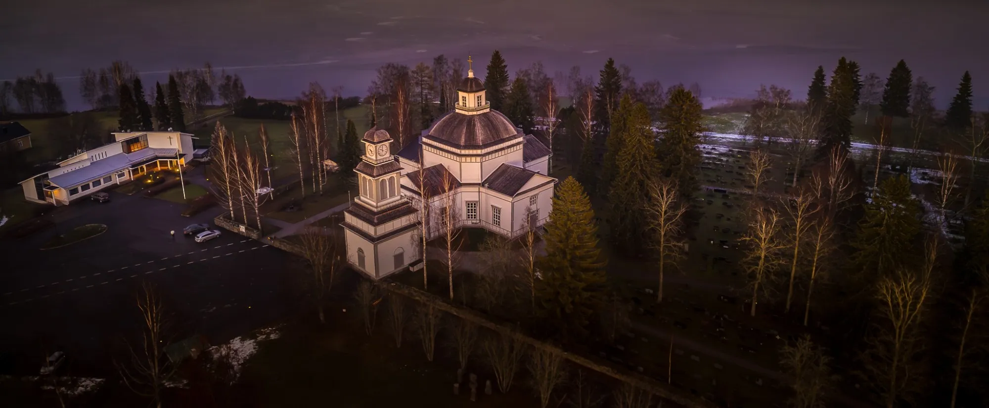 Ilmakuva Alajärven kirkosta, taustalla usvainen järvi ja saaret